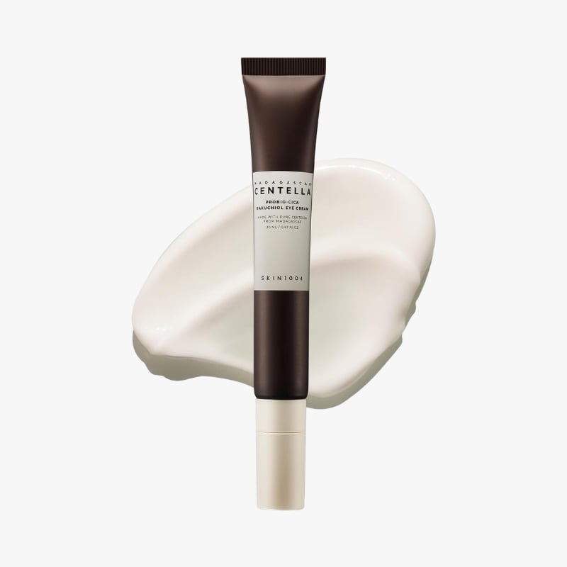 Dark brown skincare tube labeled Centella placed over a white cream smear on a light background