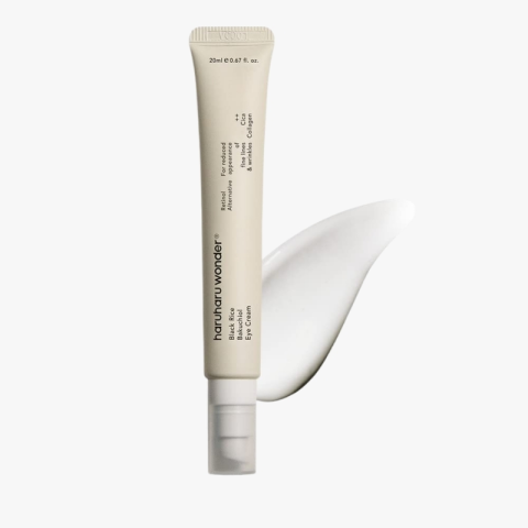 Beige squeeze tube of eye cream with a white cap, upright next to a swirled cream patch on a light background.