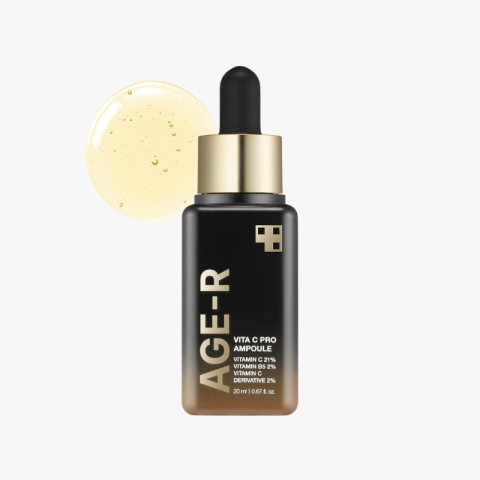 AGE-R Vita C Pro Ampoule bottle with dropper, black to gold gradient, and a circular drop of serum beside it on a white background