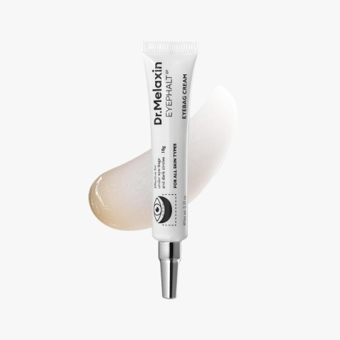 Tube of Dr. Melaxin EyeBag Cream with applicator, placed on a light beige makeup smear against a white background.