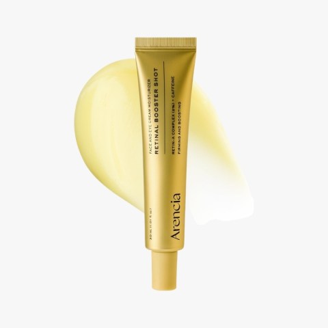 Gold skincare tube labeled Arencia Retinol Booster Shot with a pale yellow cream smear behind it on a light background.