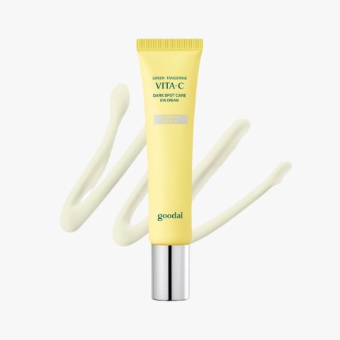 Yellow Goodal Vita-C eye cream tube labeled 'Dark Spot Care' with cream swirls behind it on a white background.