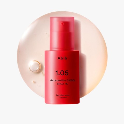 Red Abib 1.05 serum bottle with pump, text reads Astaxanthin 0.05% NAD 1% on a pale circular backdrop.