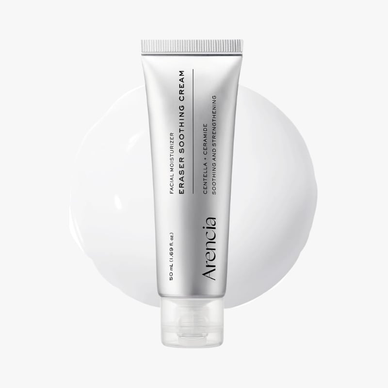 Silver tube of facial moisturizer labeled 'Eraser Soothing Cream' standing upright against a white background with a pale circle behind it.