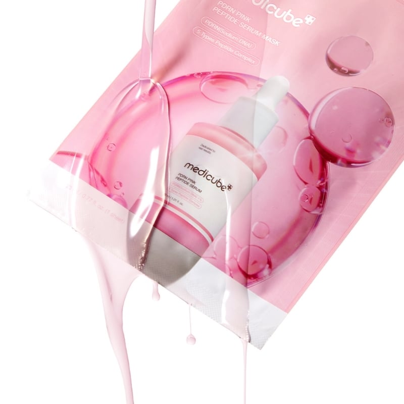 Pink cosmetic serum bottle with dropper on pink packaging, with glossy liquid splashes and droplets.