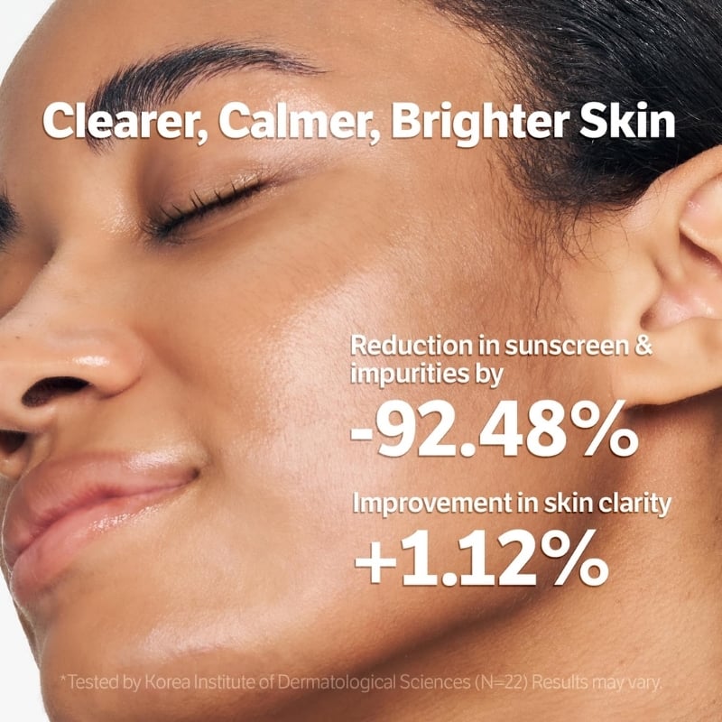 Close-up of a woman's dewy face with bold white text claiming 'Clearer, Calmer, Brighter Skin' and stats: -92.48% impurities reduction and +1.12% clarity improvement.