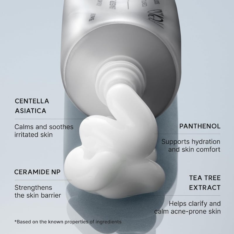 Cosmetic tube dispensing a white cream; labels show Centella Asiatica, Ceramide NP, Panthenol, Tea Tree Extract and their skin benefits.