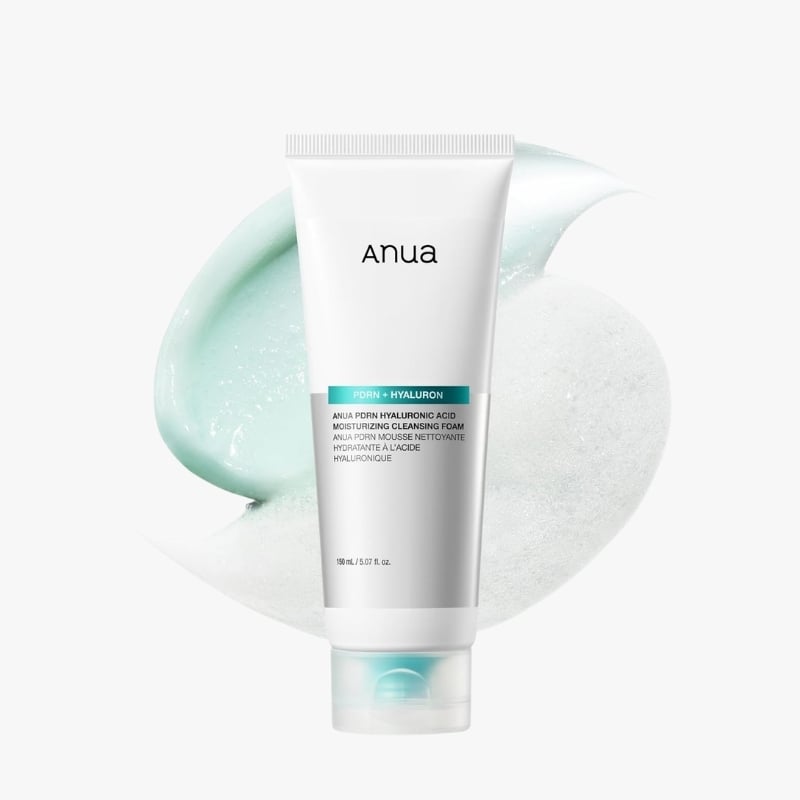 Tube of Anua PDRN + Hyaluron Moisturizing Cleansing Foam, white with turquoise label, against mint and foam background.