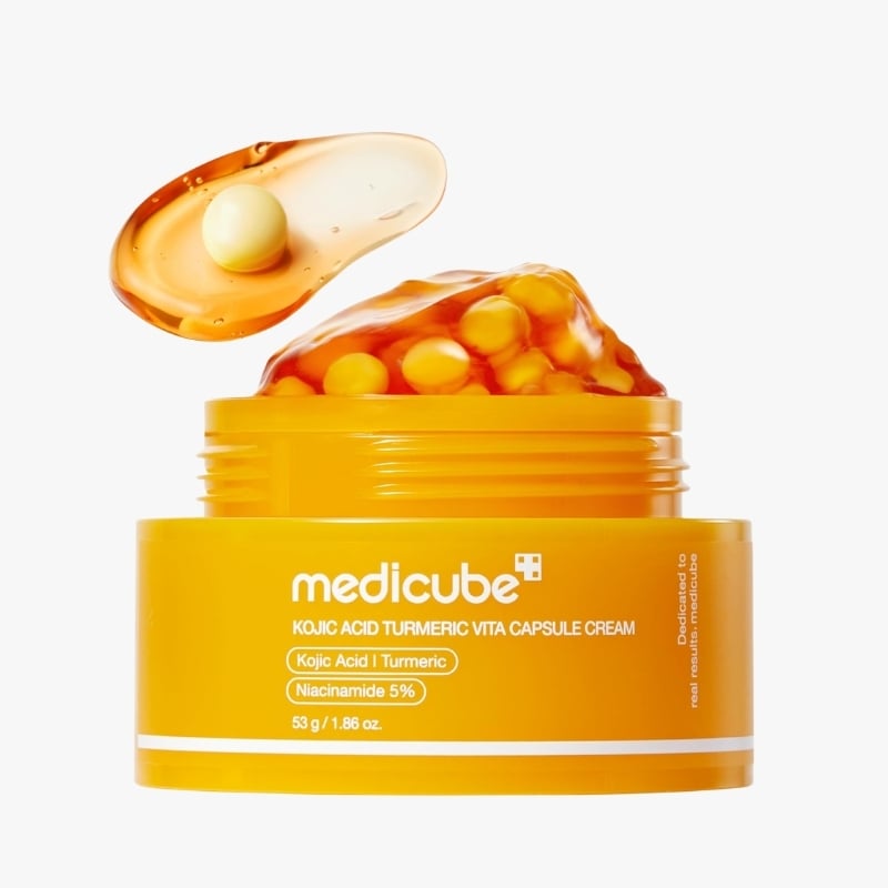 Yellow Medcube Kojic Acid Turmeric Vita Capsule Cream jar with open lid and orange capsules spilling out.